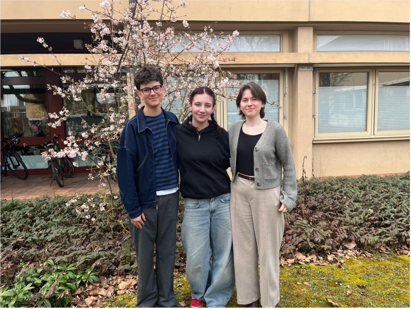 Die drei Schülersprecherinnen und Schülersprecher des Frobenius-Gymnasiums vor dem Schulgebäude.