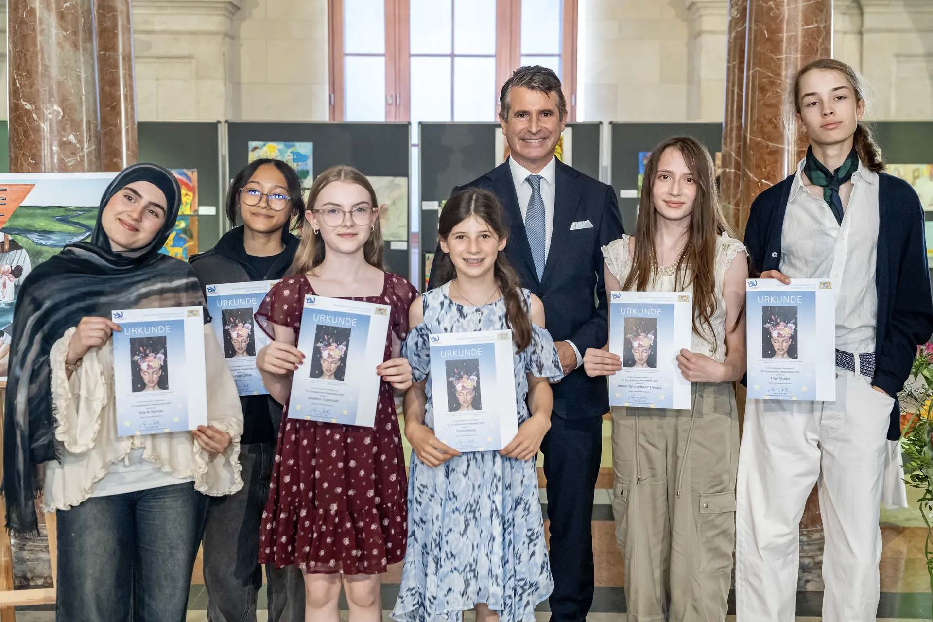 Die beiden Bundessiegerinnen Aya und Andrea mit Staatsminister Eric Beißwenger beim Festakt in der Bayerischen Staatskanzlei in München